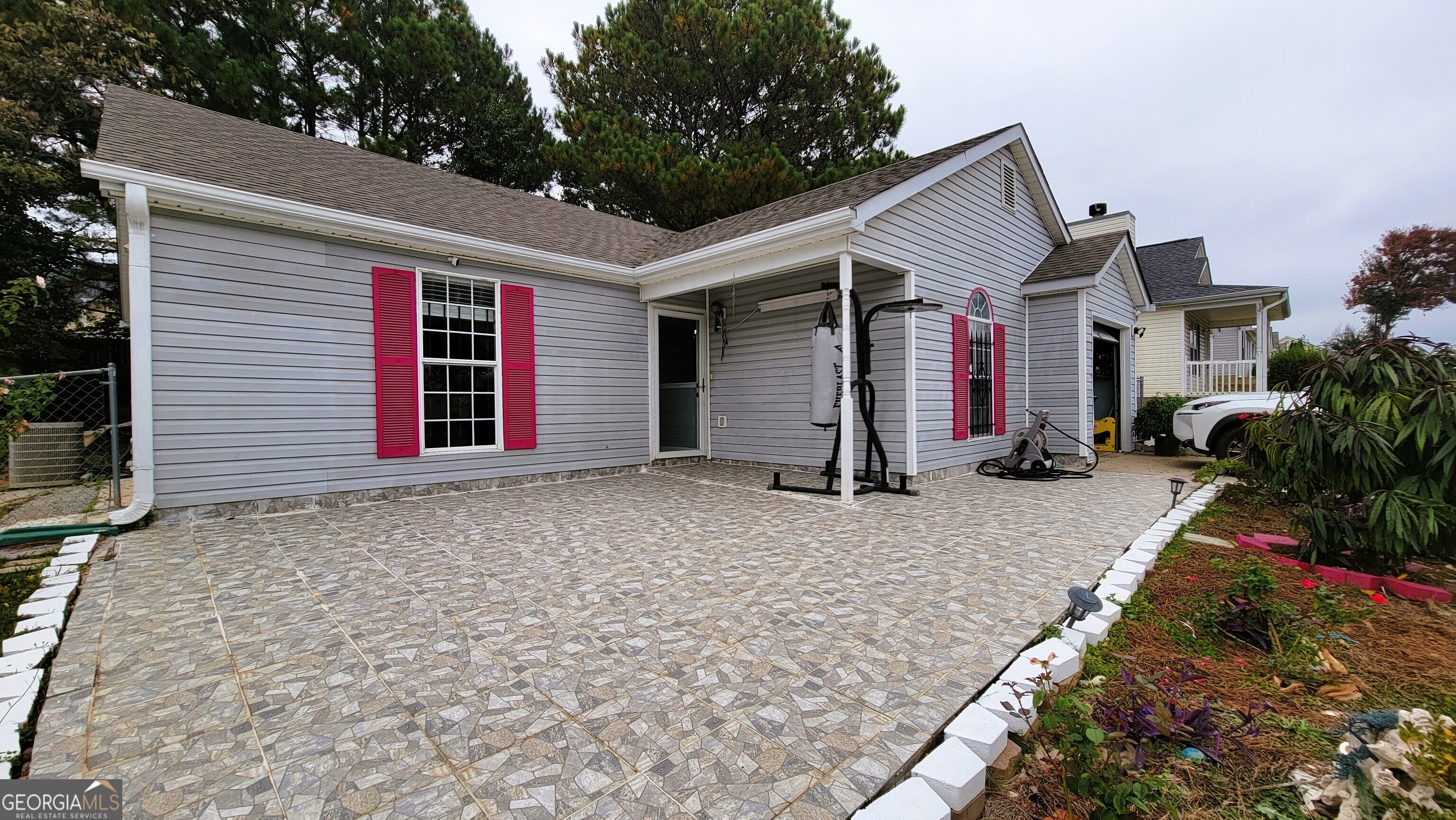 a view of house with backyard and trees in the background