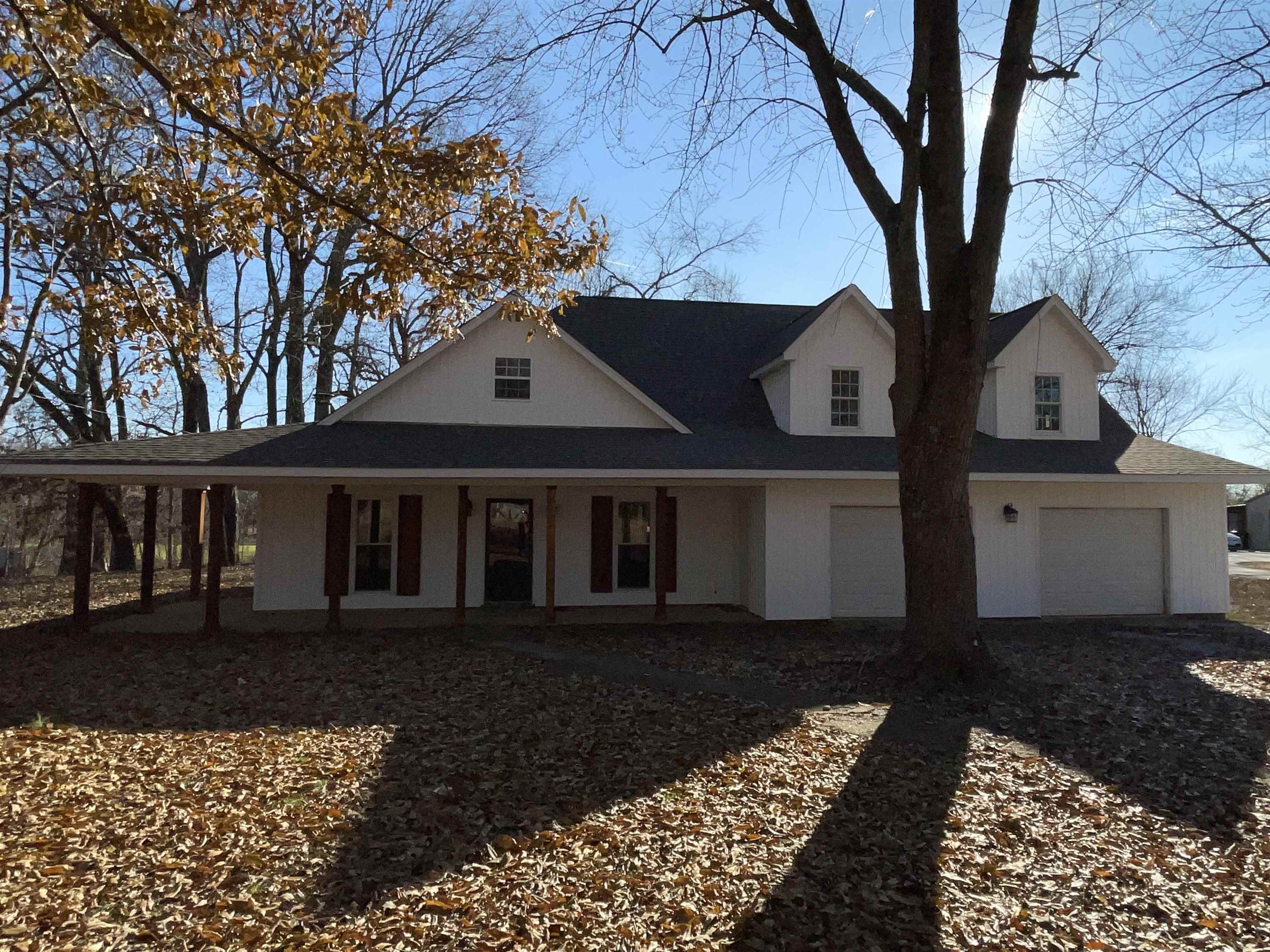 Farmhouse-style home with a garage and covered porch