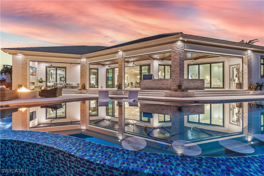 a view of a house with pool and sitting area