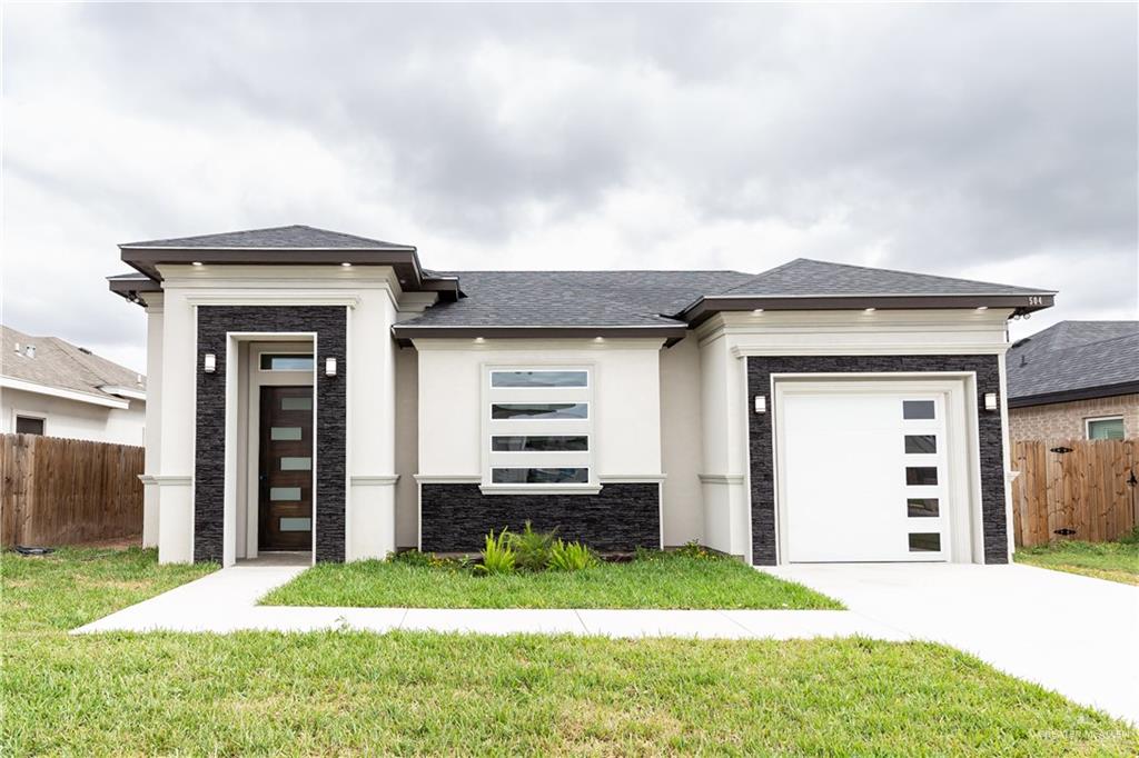 Prairie-style home featuring a front lawn and a garage