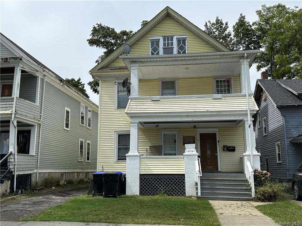 View of front of house with a porch and a front lawn