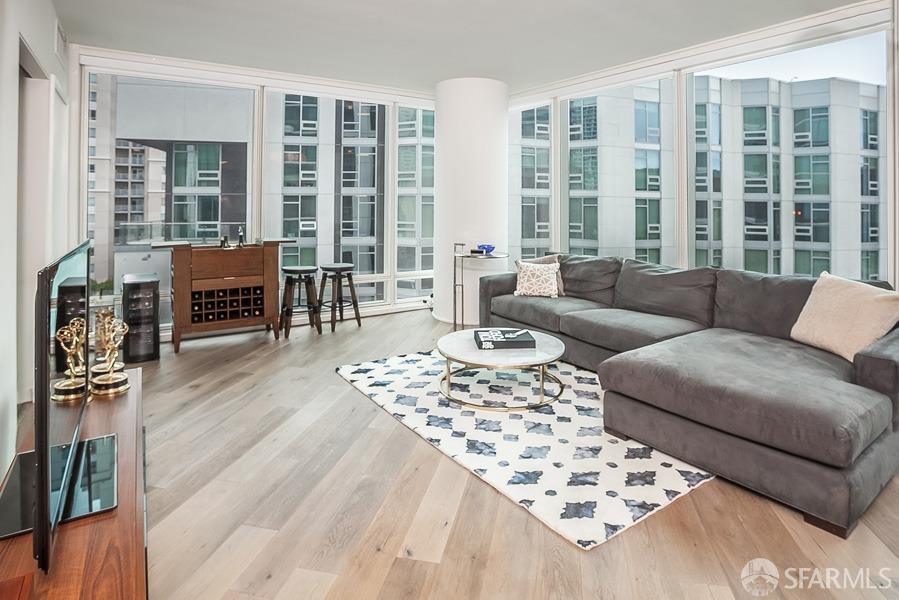 a living room with furniture and a floor to ceiling window next to a large window