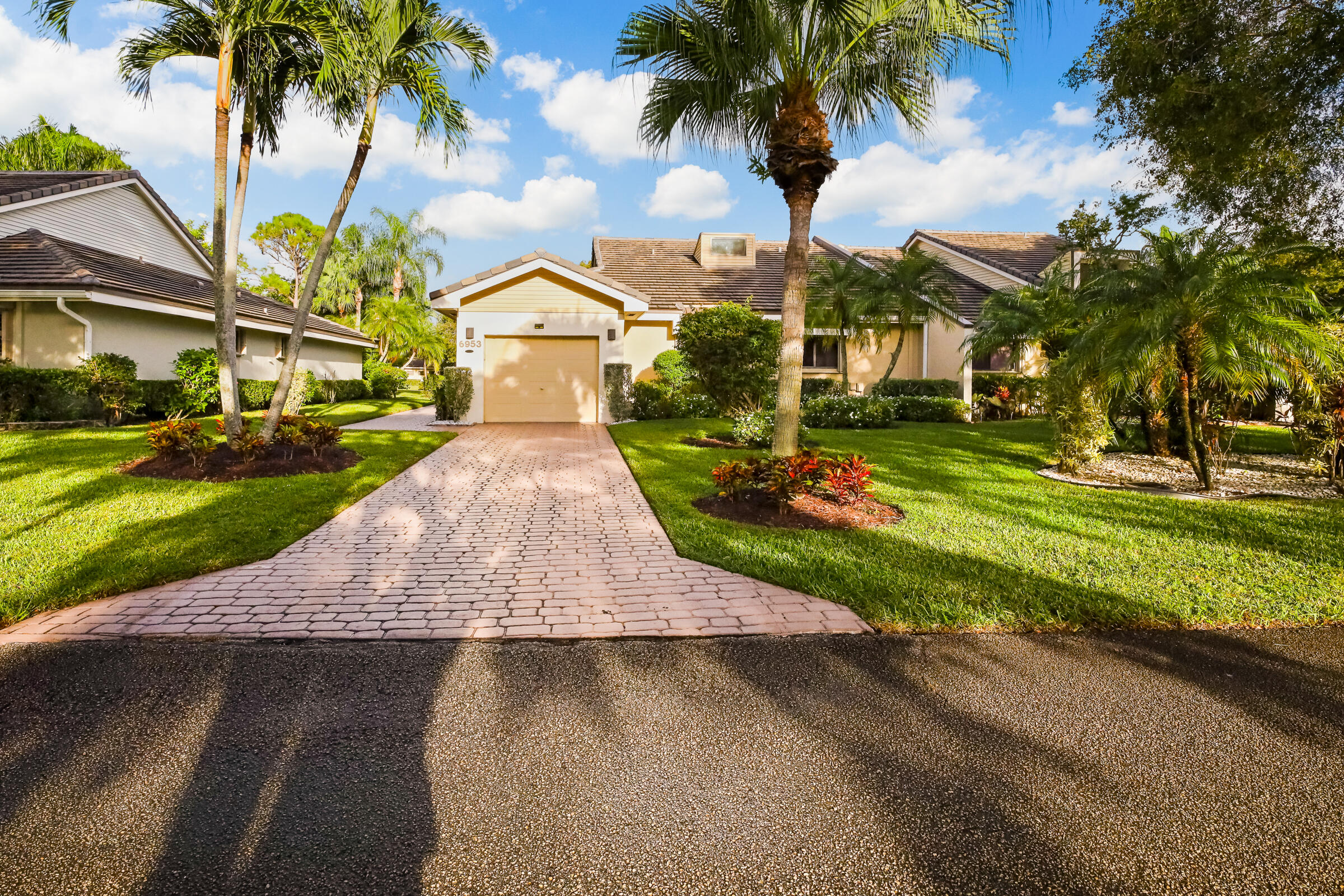 a front view of a house with a yard and potted plants