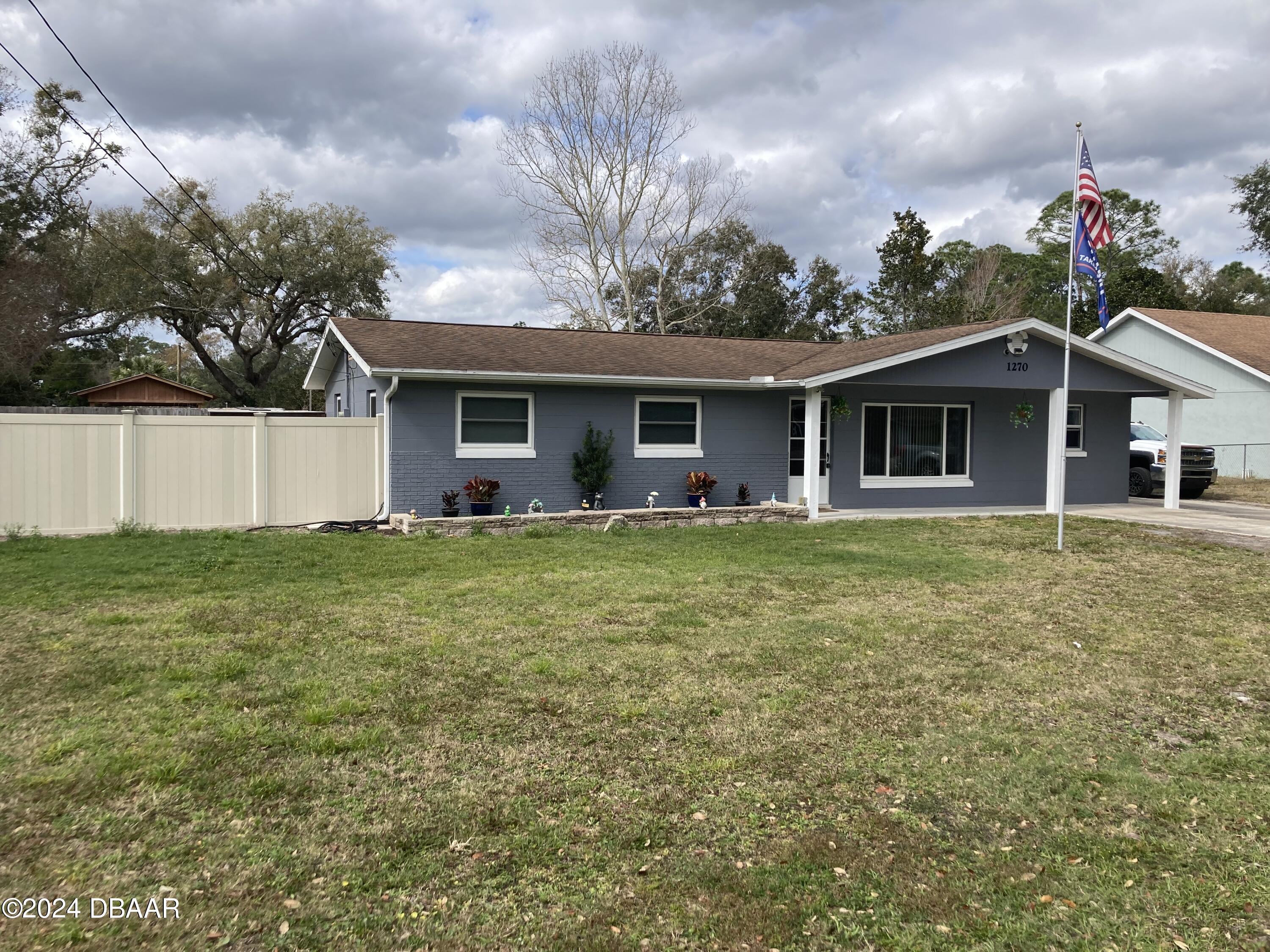 a front view of house with yard and trees around