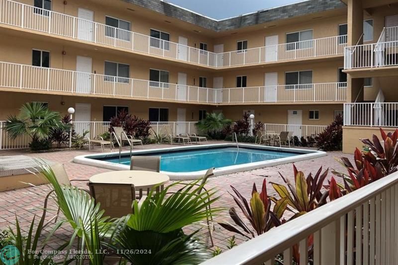 a swimming pool with outdoor seating and plants