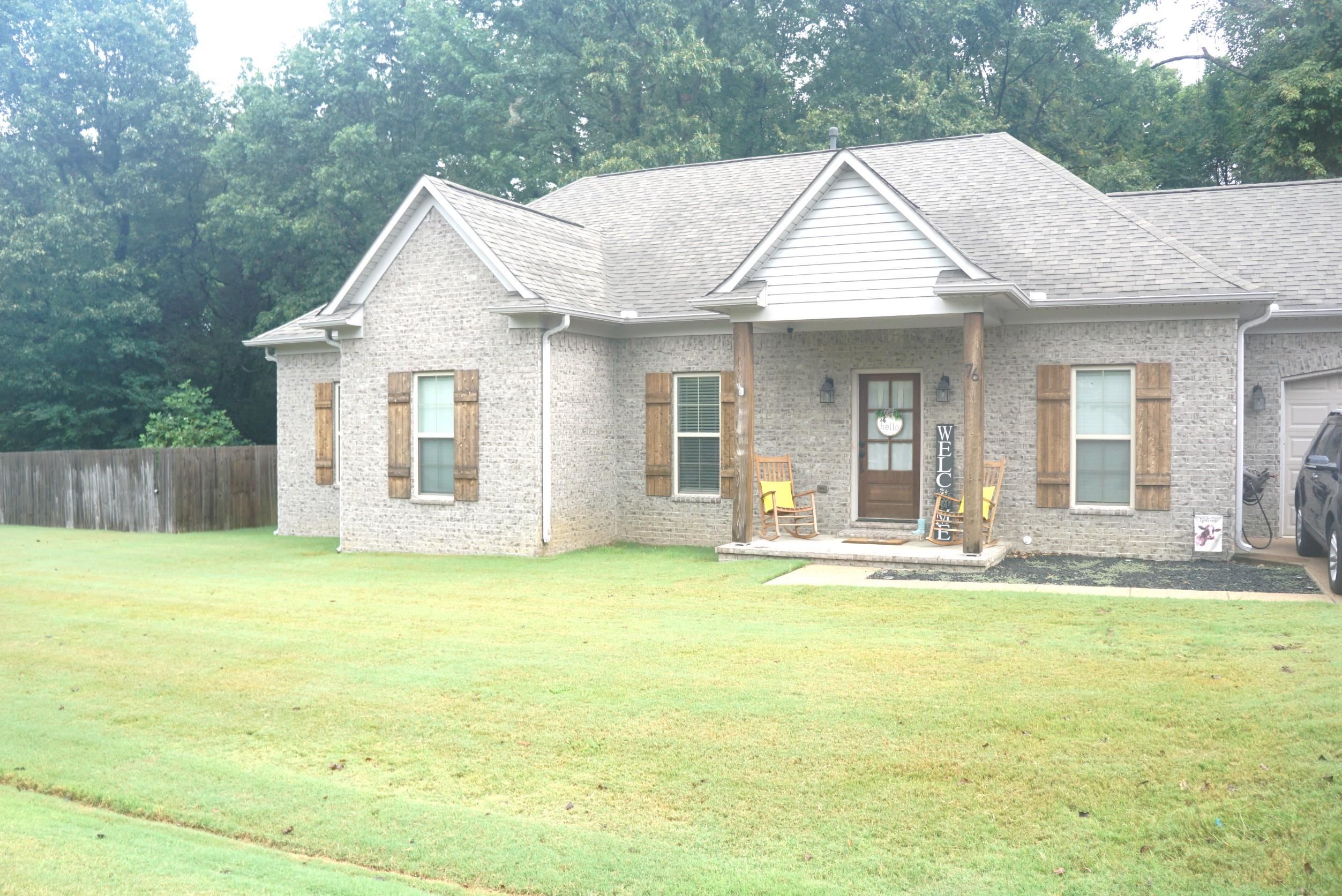 a view of a house with a yard and sitting area