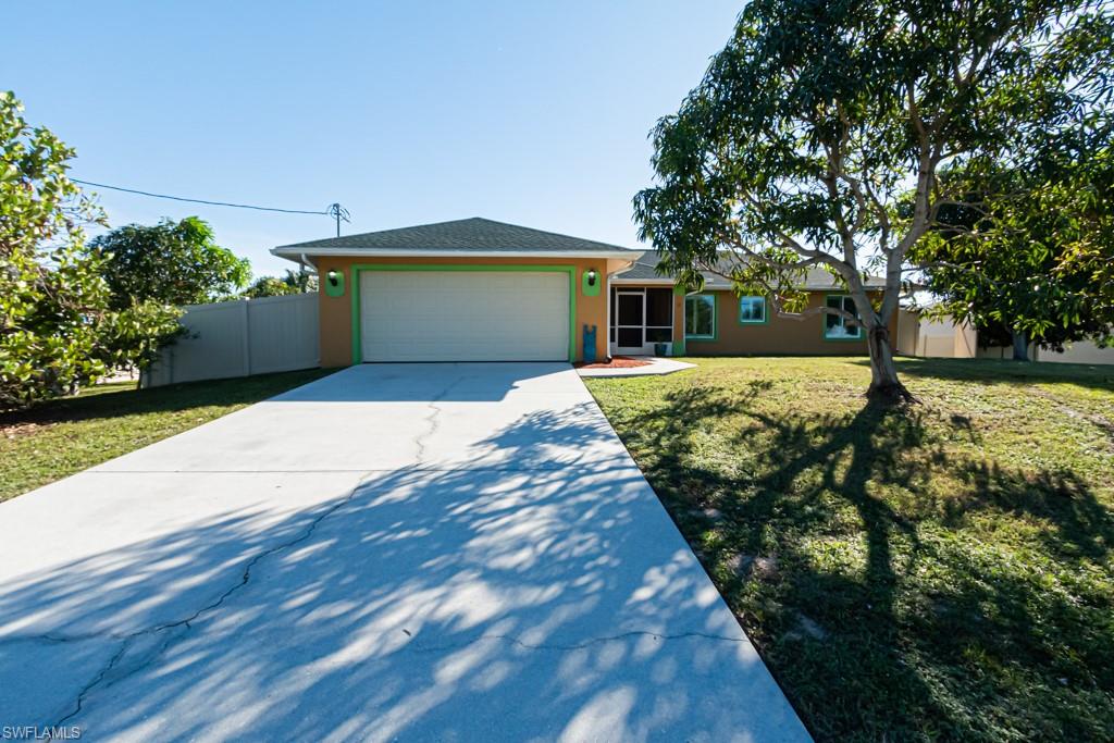 Single story home with a front yard and a garage