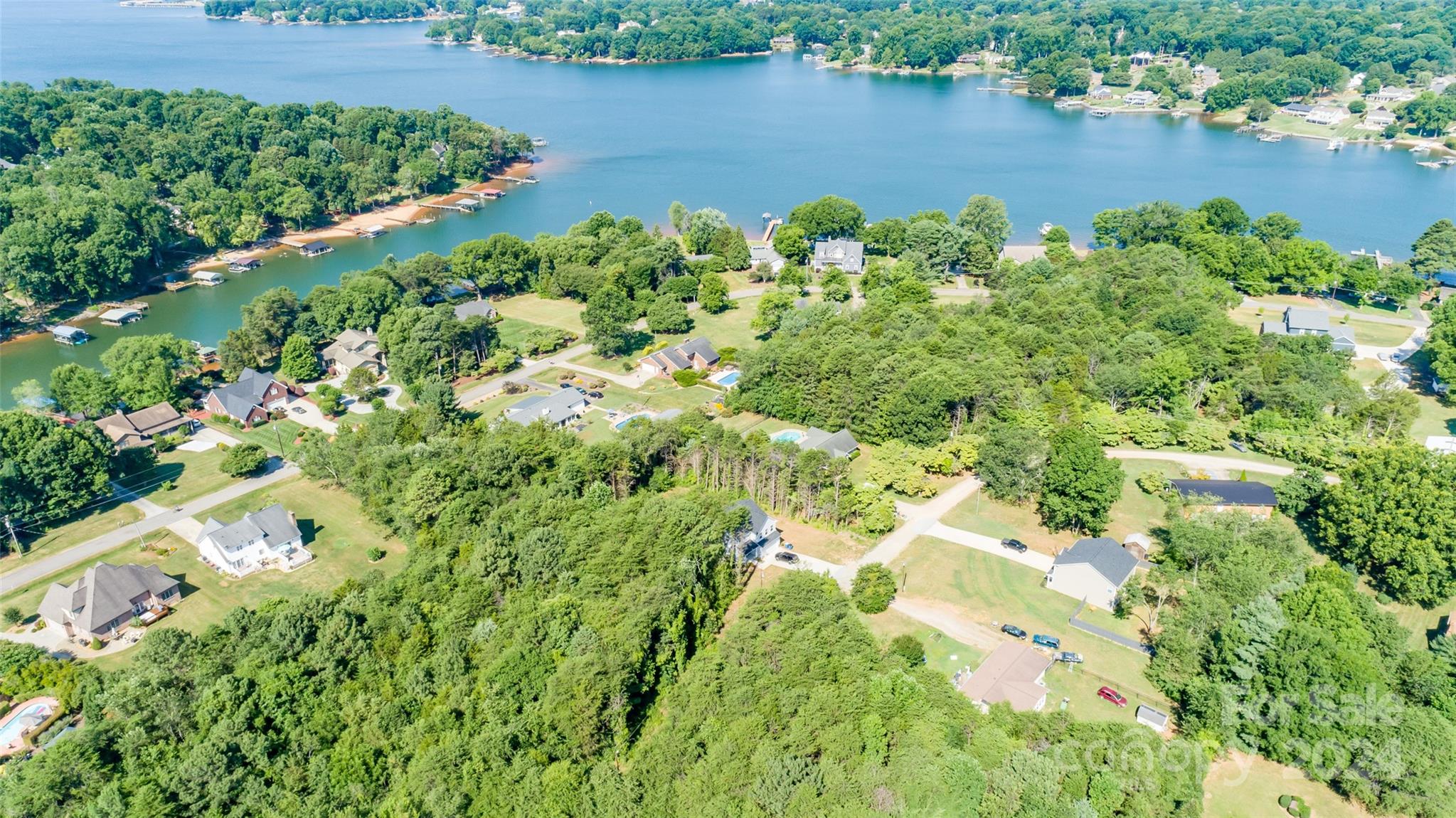 an aerial view of a house with a yard and lake view