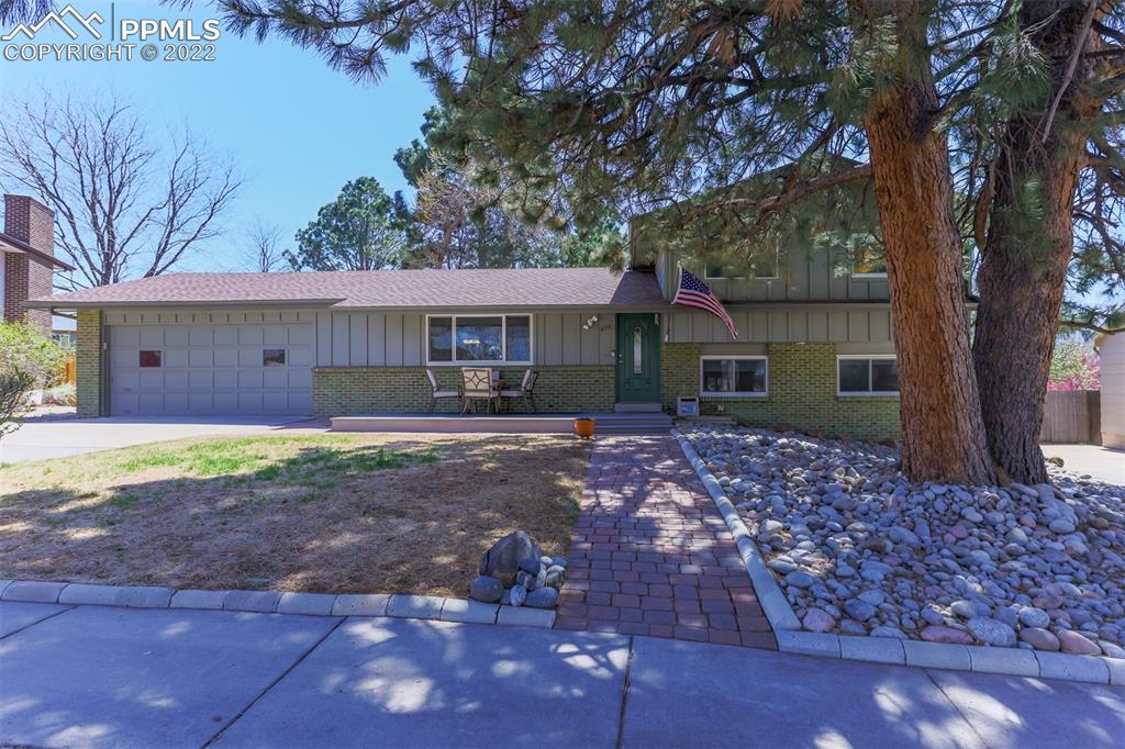 a view of a house with a yard and tree