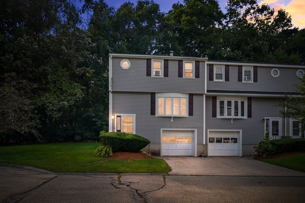 a front view of a house with a garden and yard