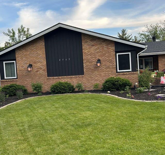 a brick house with a yard plants in front of it