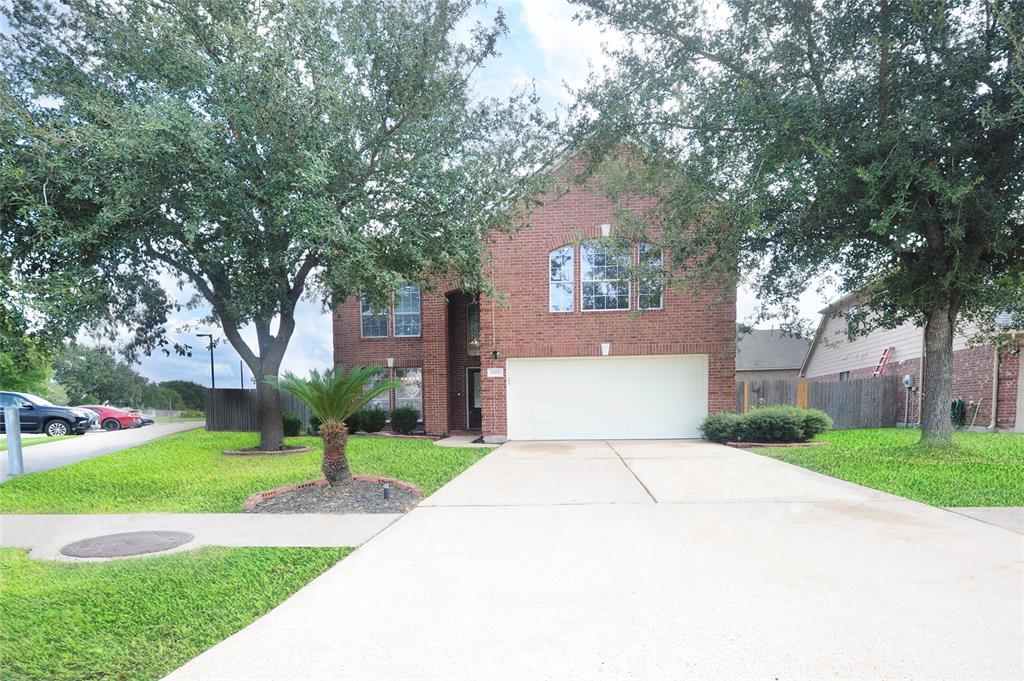 a front view of a house with a yard and tree