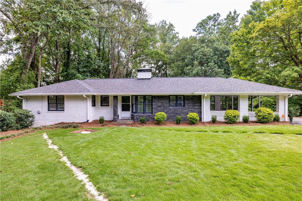 a view of a house with a yard and sitting area