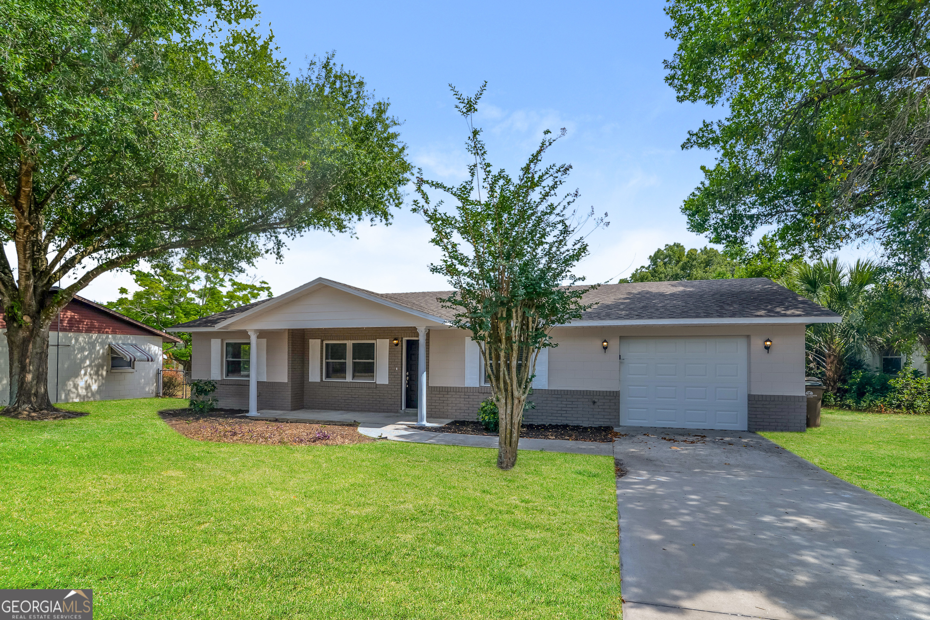 a front view of a house with a garden and yard