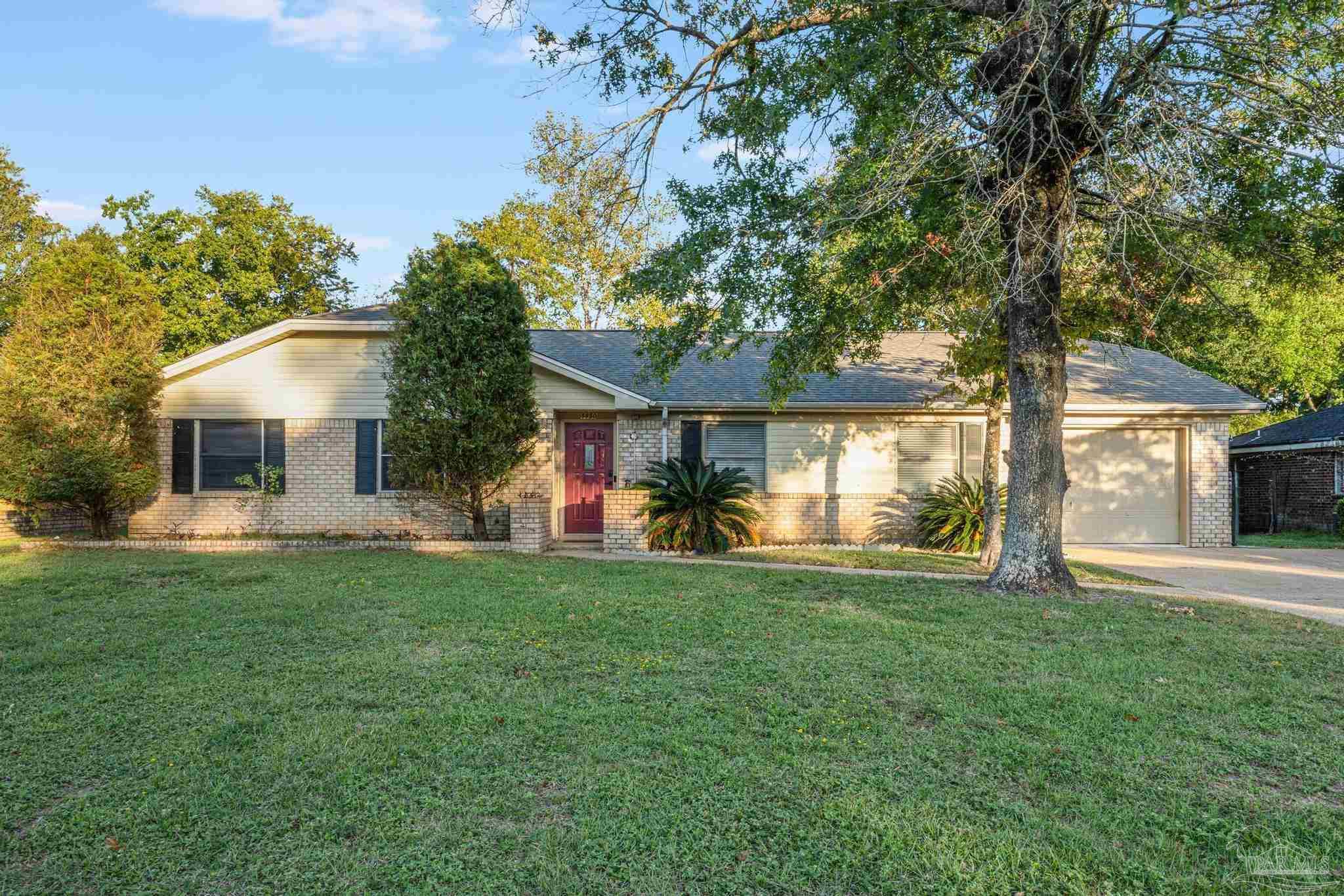 a view of a house with a yard and a tree