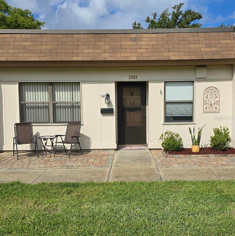 a front view of a house with outdoor seating and a yard