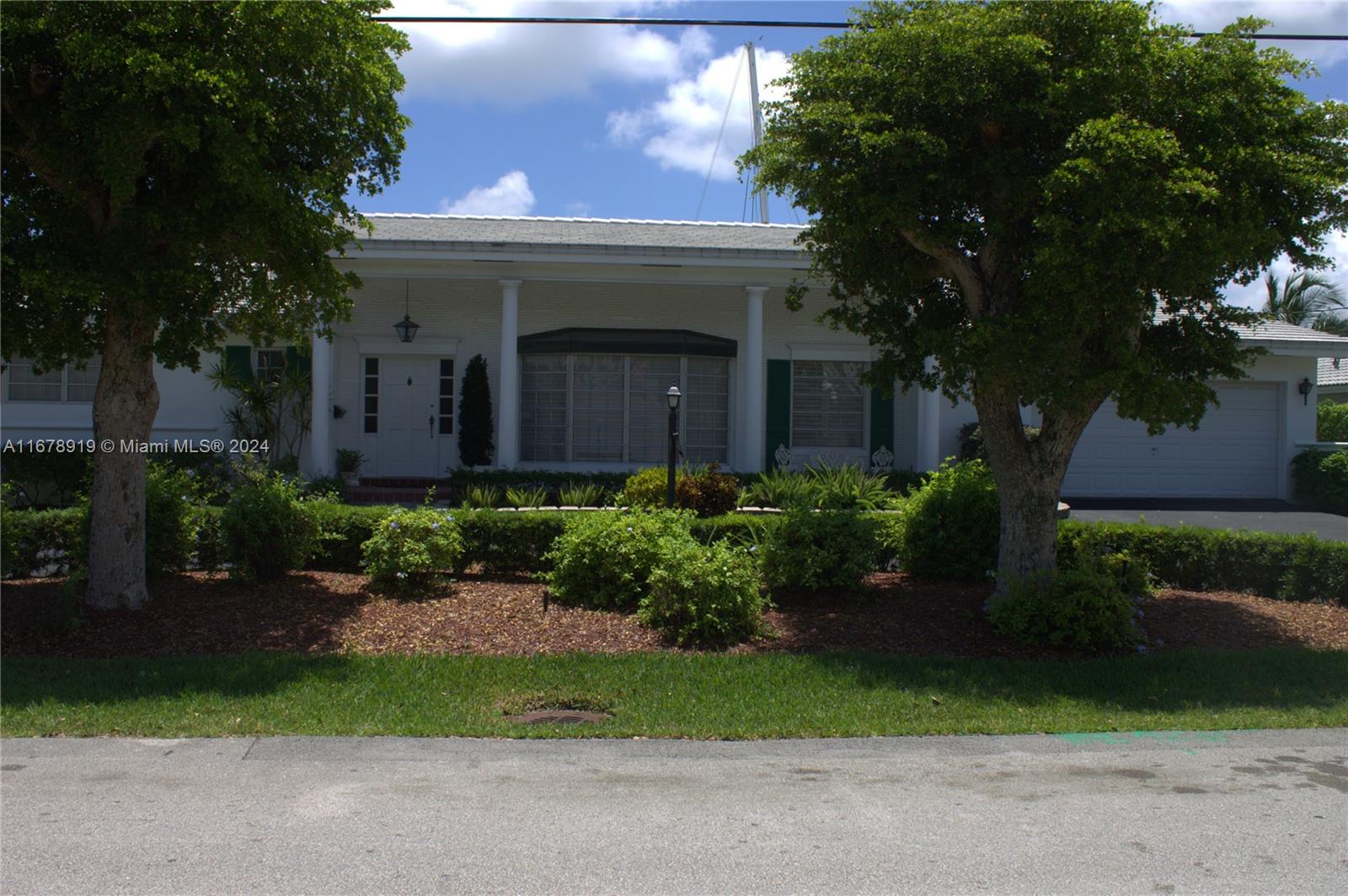 a front view of a house with a garden