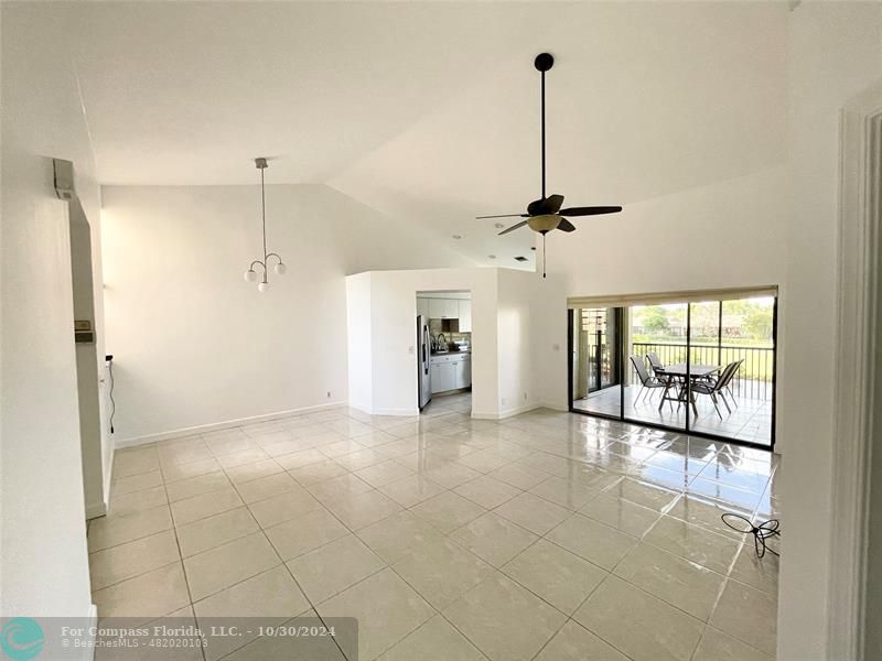 a view of a room with a ceiling fan and window