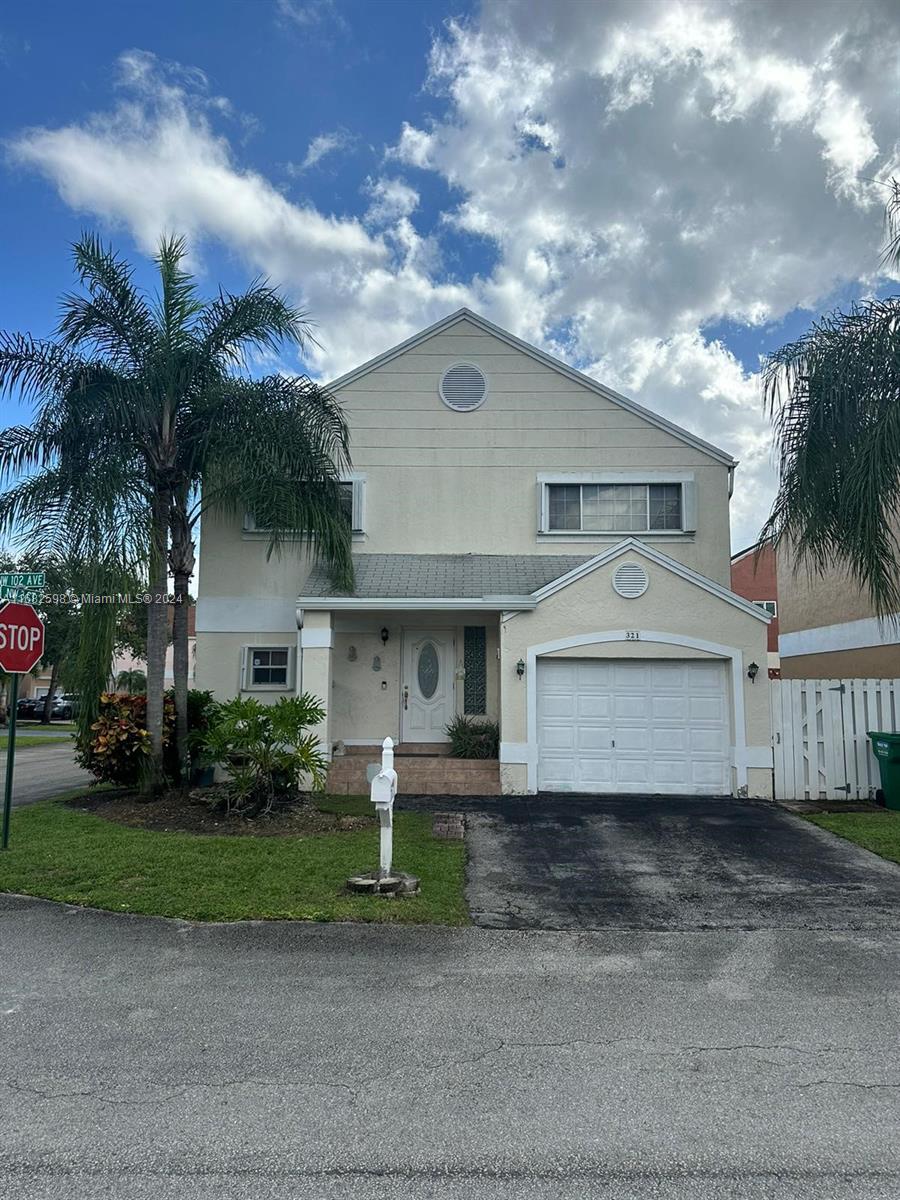 a front view of a house with a yard and garage