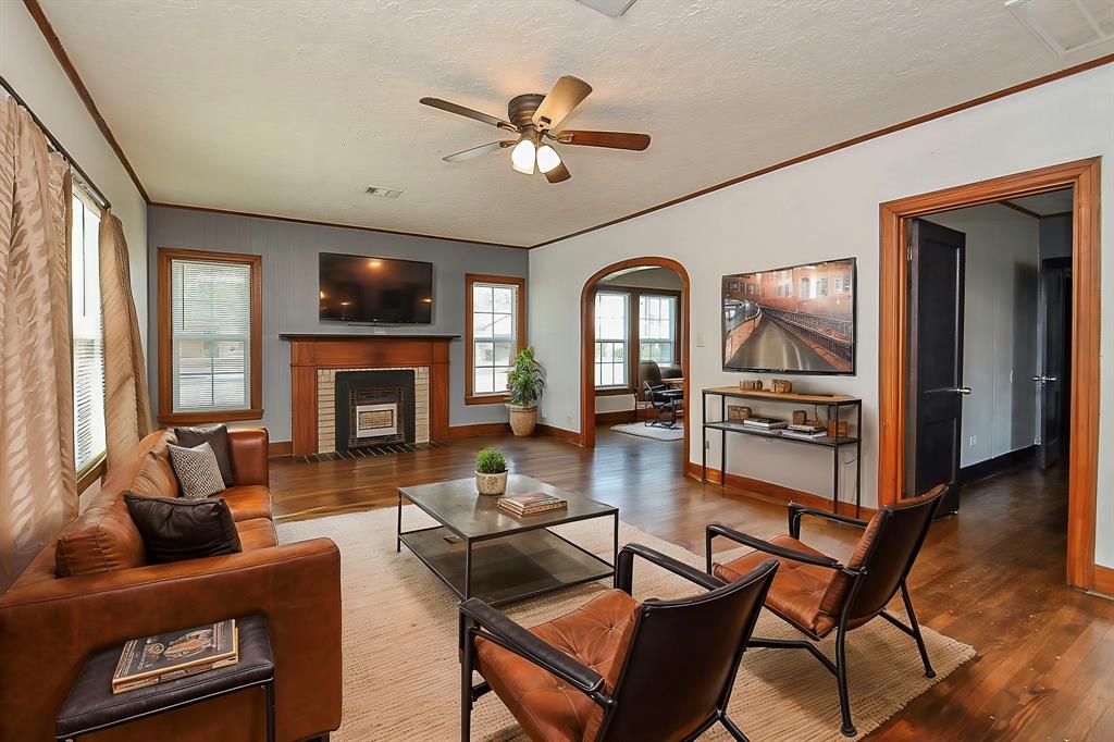 a living room with furniture a fireplace and a large window