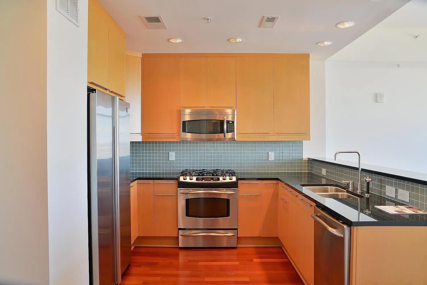 a kitchen with a sink a stove top oven and refrigerator