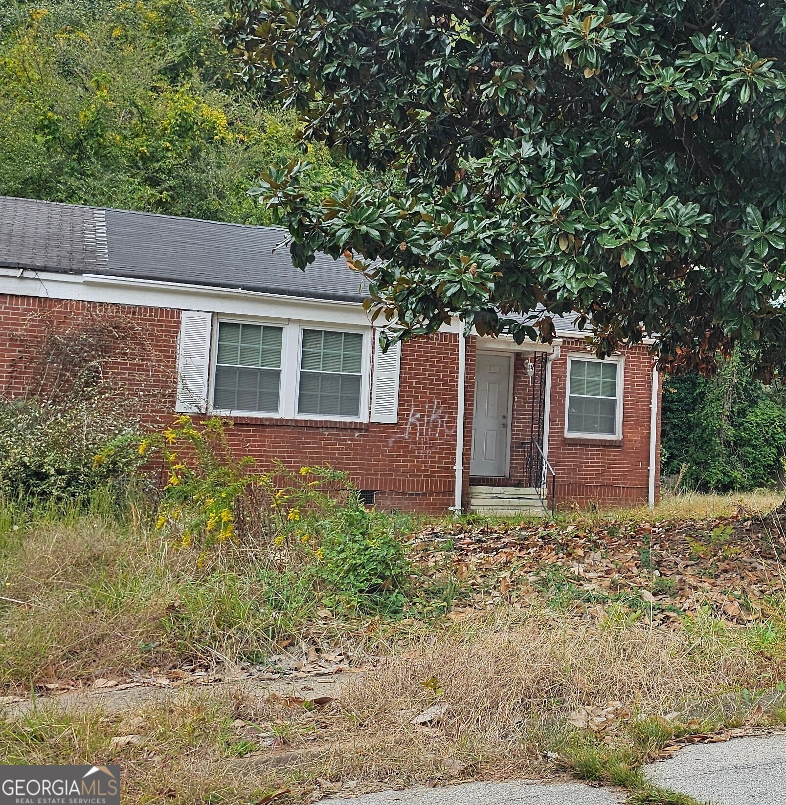 a red brick house with trees in front of it