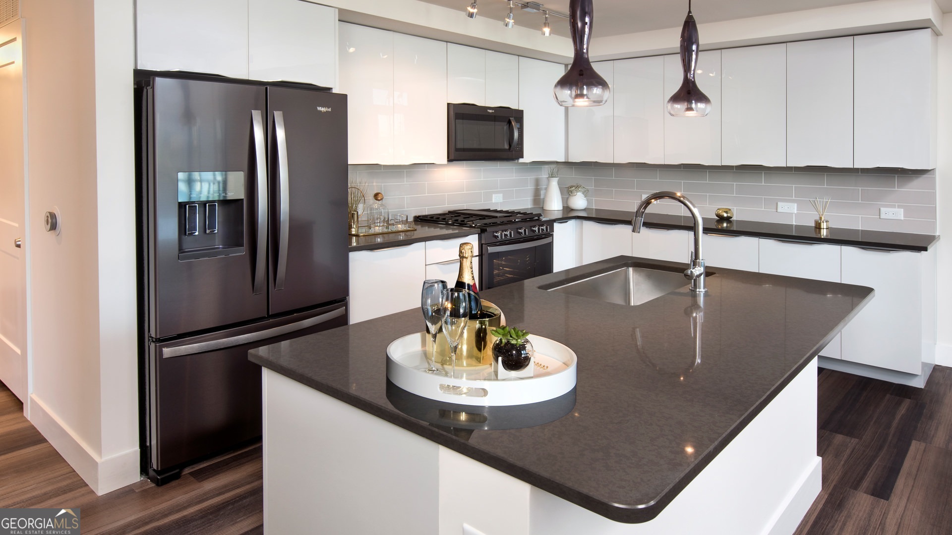 a kitchen with stainless steel appliances granite countertop a sink a refrigerator and a stove