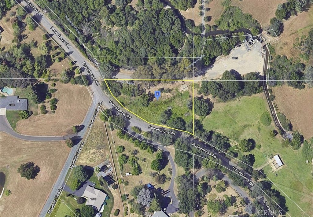 an aerial view of a house a yard and mountain