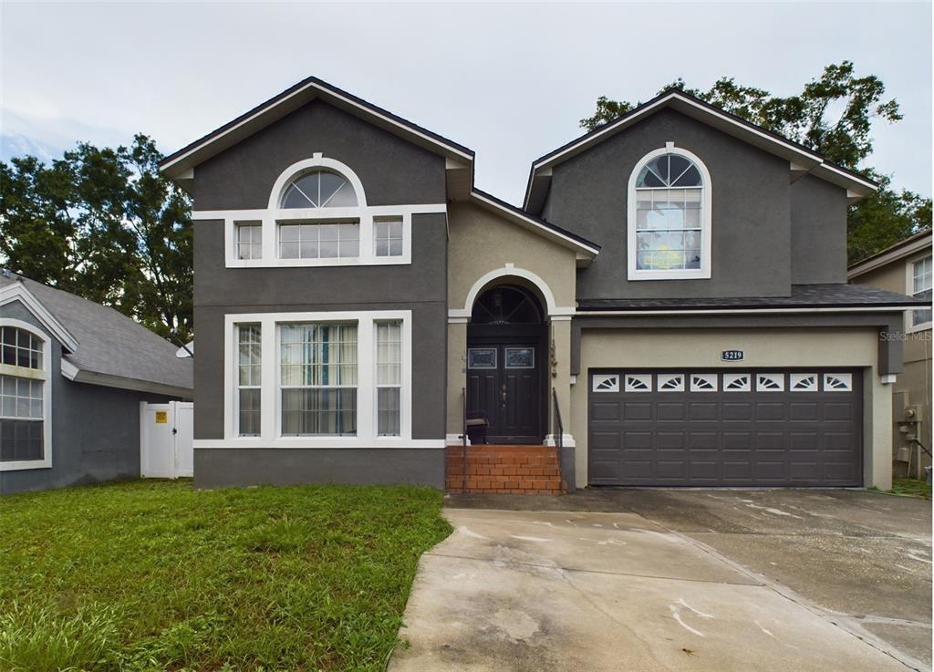 a front view of a house with a yard and garage