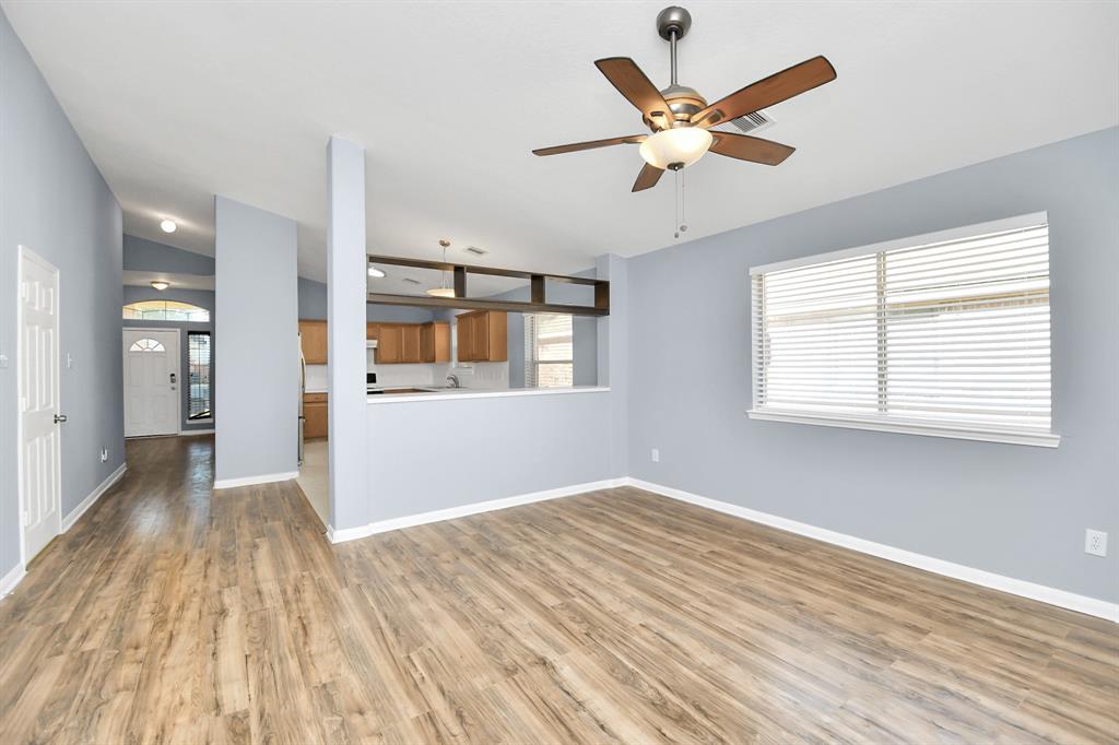 A beautiful 3 bed/2 bath home with spacious living room and wood floors, offering a cozy and inviting atmosphere. A lovely view of the kitchen and dining area, creating a seamless connection between these living spaces while maintaining distinct areas for comfort and functionality.