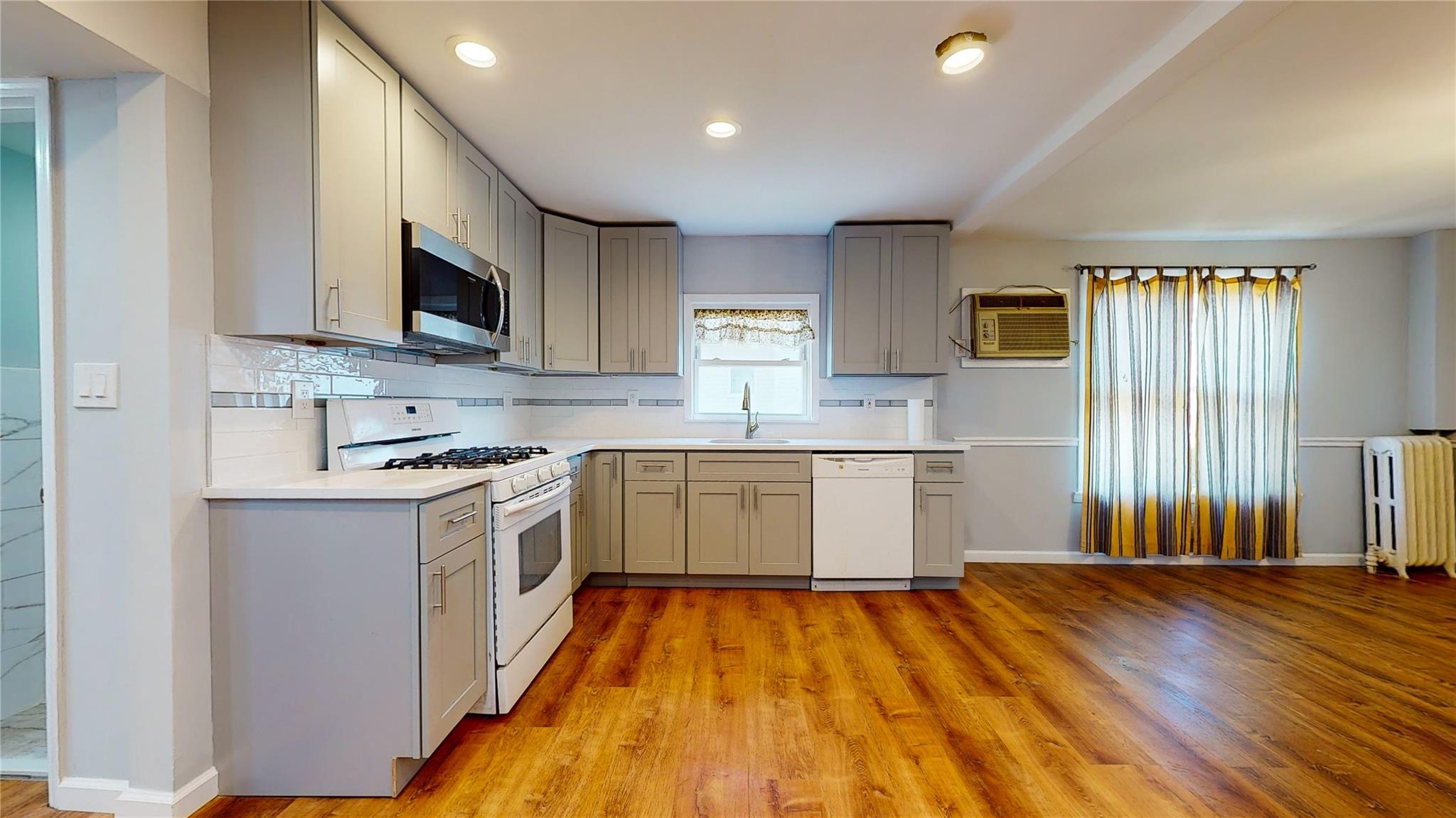 a kitchen with stainless steel appliances granite countertop a stove a sink and a microwave