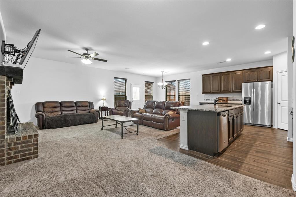 a living room with furniture a kitchen view and a refrigerator