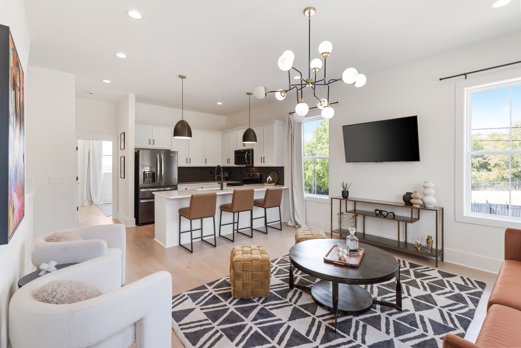 a living room with fireplace a flat screen tv and kitchen view