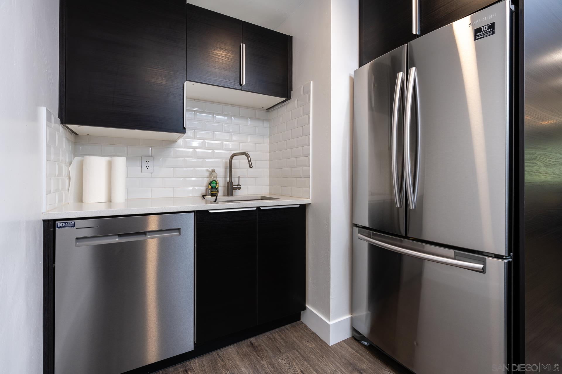 a kitchen with stainless steel appliances a refrigerator sink and cabinets