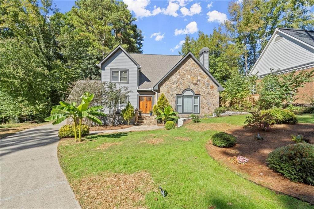 a front view of a house with yard and green space