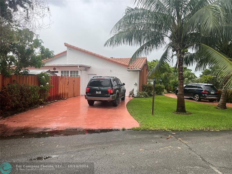 a car parked in front of a house with a yard