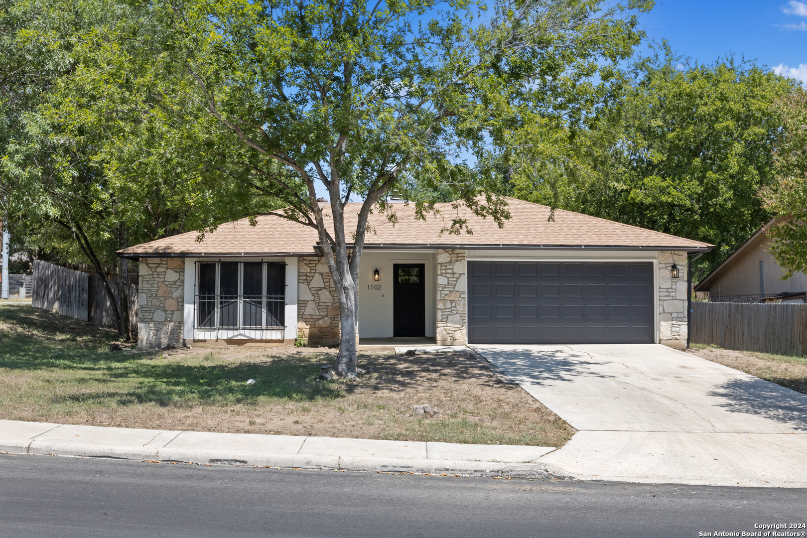 a front view of a house with yard and parking