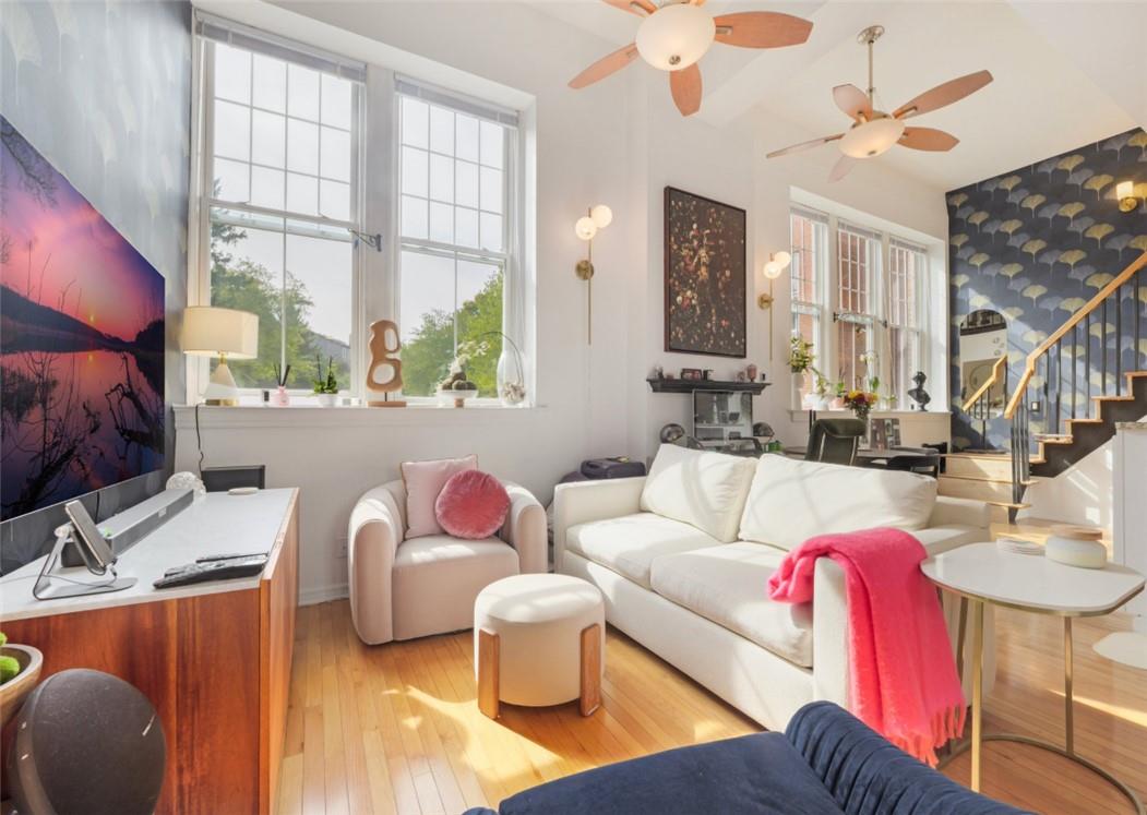 Living room with light hardwood / wood-style floors and ceiling fan