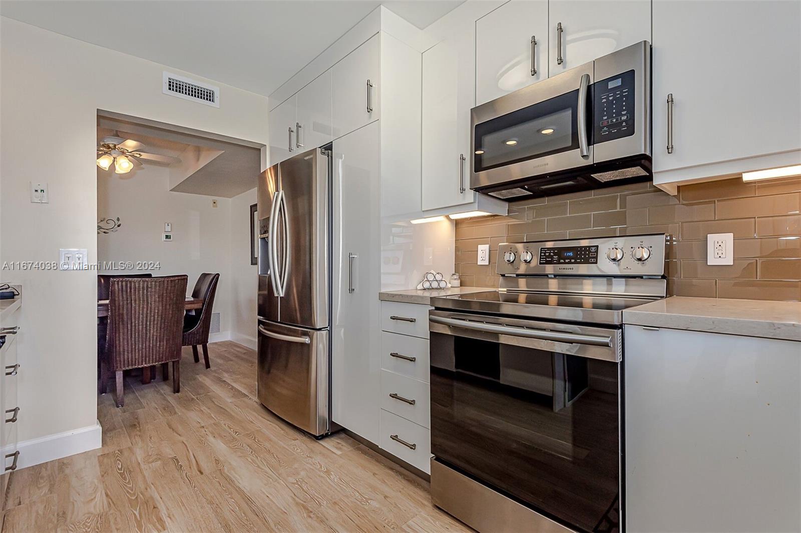 a kitchen with stainless steel appliances granite countertop a stove microwave and refrigerator