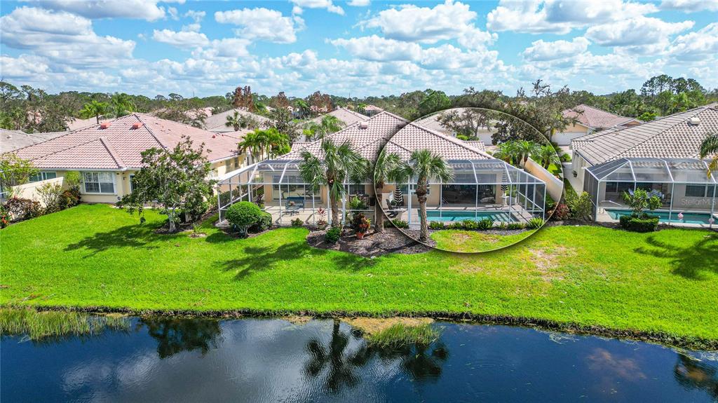 an aerial view of a house with swimming pool and lake view