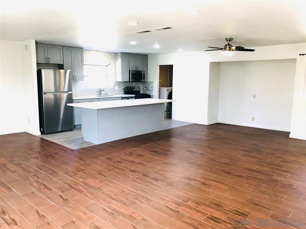 a view of kitchen with stainless steel appliances granite countertop a refrigerator and a sink