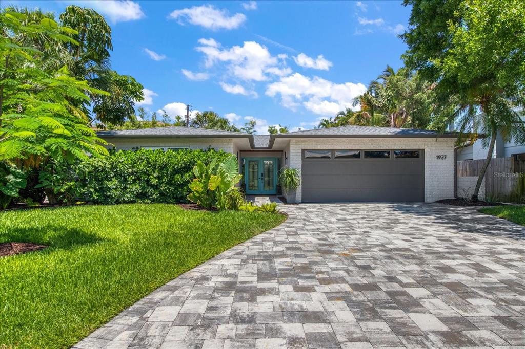 a front view of a house with a yard and a garage