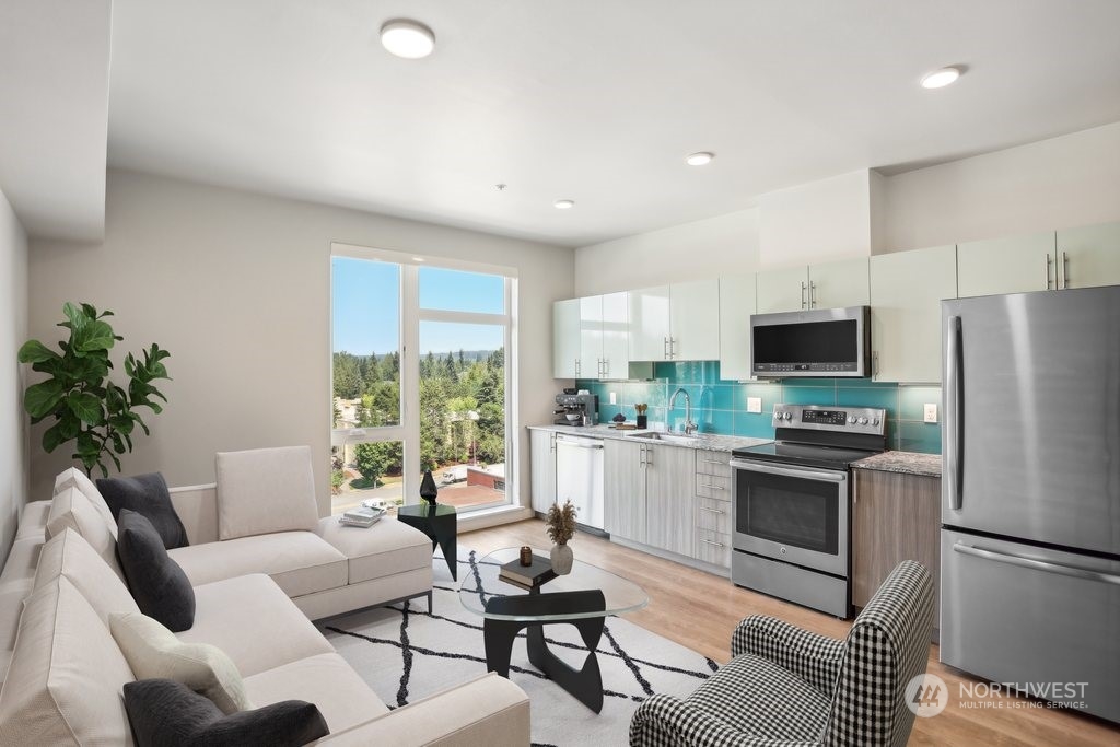 a kitchen with furniture a large window and stainless steel appliances