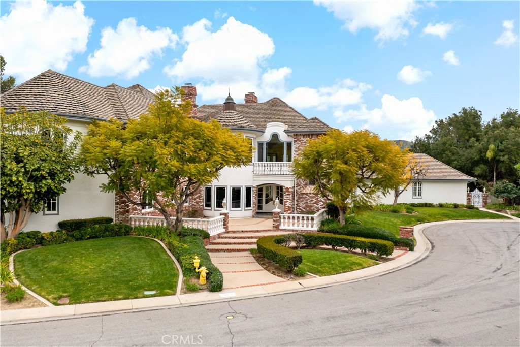 a front view of a house with a yard and trees