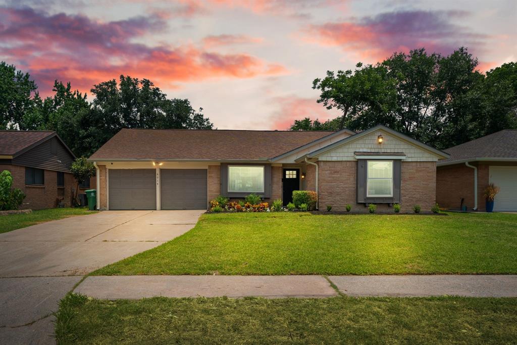 a front view of a house with a yard and trees