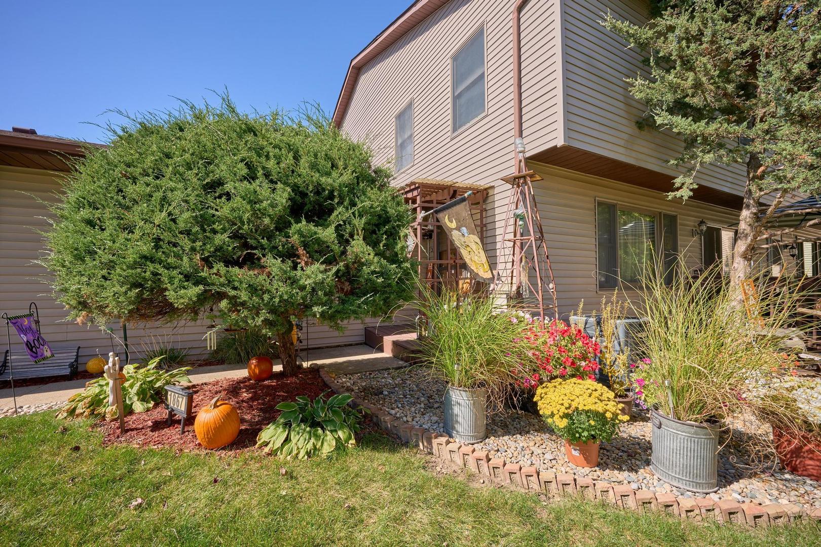 a front view of a house with a yard and a garden