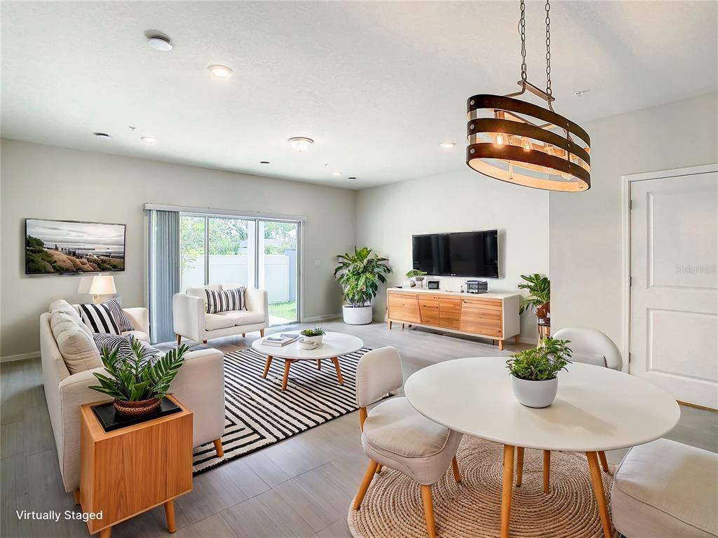 a living room with furniture potted plant and a flat screen tv