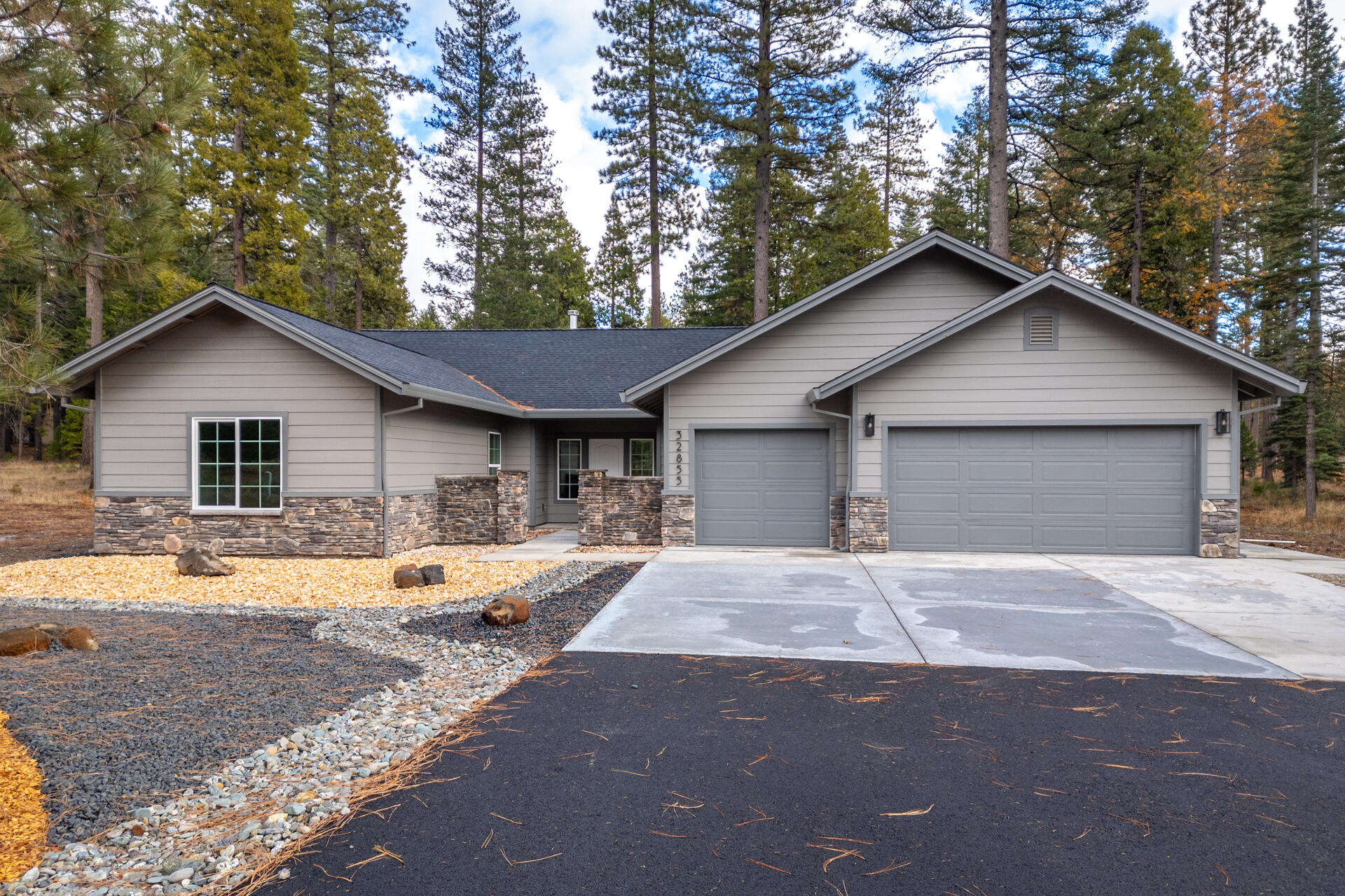 a front view of house with yard and trees in the background