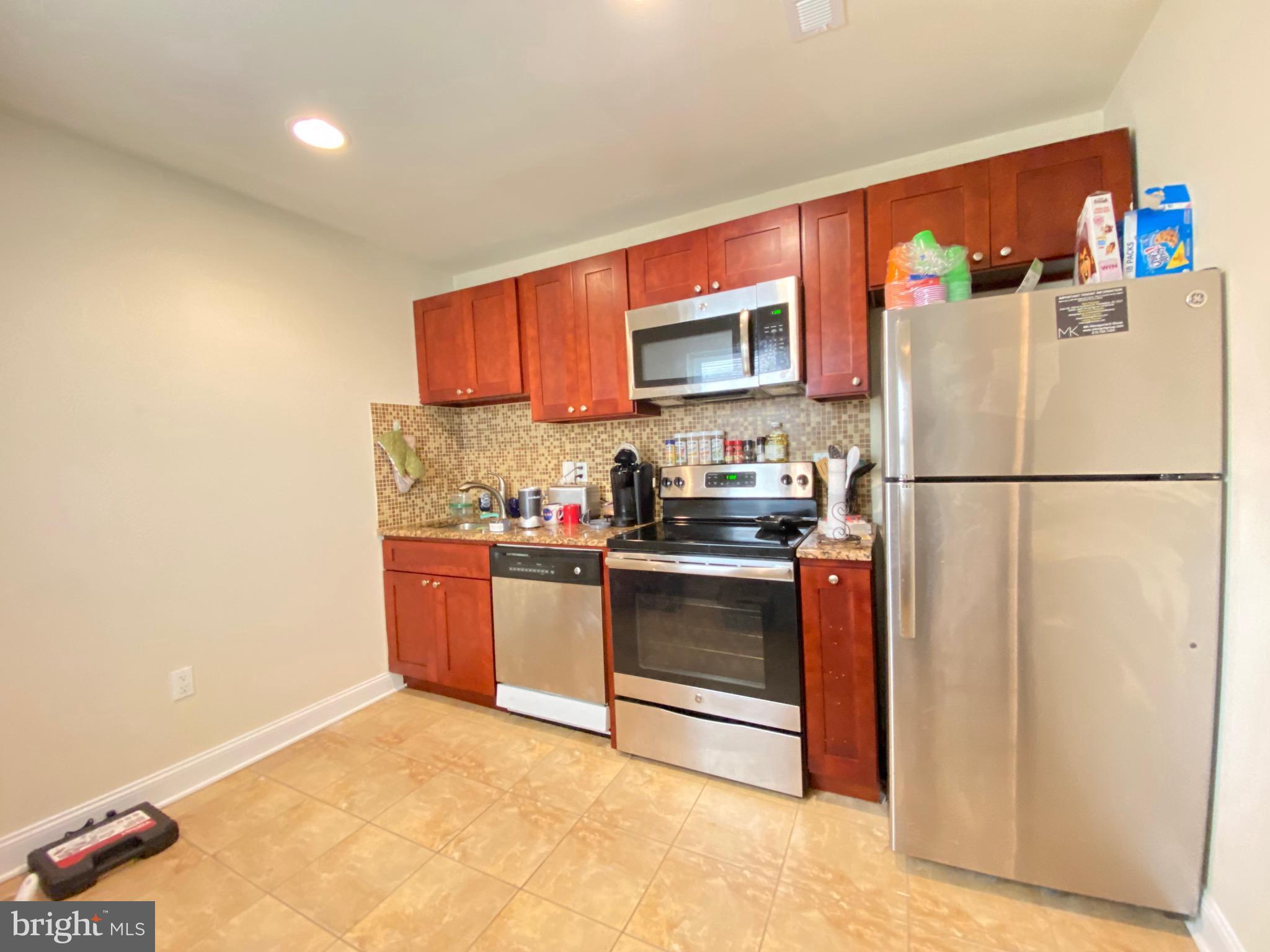 a kitchen with stainless steel appliances granite countertop a refrigerator sink stove and microwave