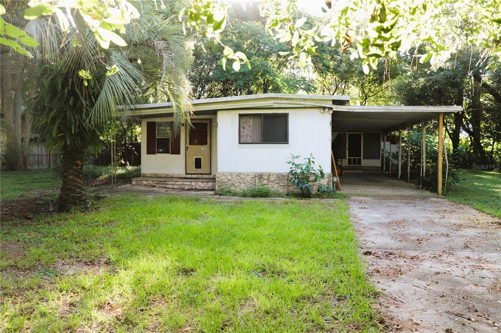 a view of a house with backyard and a tree